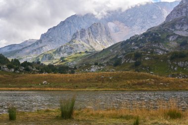 Güzel bir manzara - arka planda yüksek bir dağ sırası olan sonbahar alp gölü