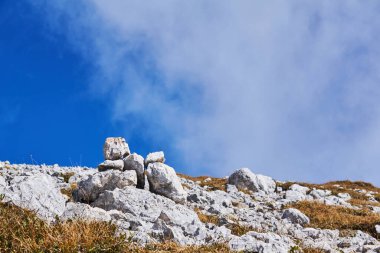 Dağ geçidi boyunca bir patika ile işaretlenmiş küçük bir cairn, yakın çekim