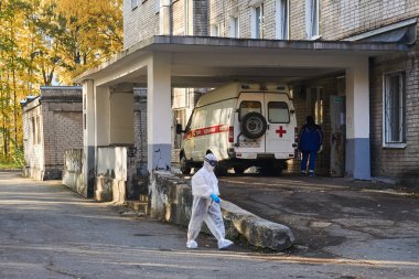 Perm, Rusya - 01 Ekim 2020: Koruyucu kıyafetli bir doktor COVID-19 hastası ambulansla getirilen hastanenin kabul bölümüne girer.