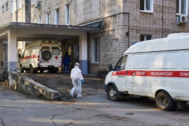 Perm, Rusya - 01 Ekim 2020: Koruyucu kıyafetli bir doktor COVID-19 hastası ambulansla getirilen hastanenin kabul bölümüne girer.