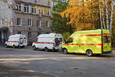 Perm, Rusya - 01 Ekim 2020: COVID-19 hastalarını getiren ambulanslar, doktorların iş yükü nedeniyle hastanenin kabul bölümünün önünde sıra bekliyor