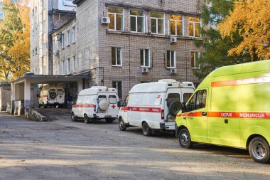 Perm, Rusya - 01 Ekim 2020: COVID-19 hastalarını getiren ambulanslar, doktorların iş yükü nedeniyle hastanenin kabul bölümünün önünde sıra bekliyor