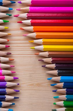Parlak renkli kalemler ahşap masa üzerinde keskinleşmiş. Okul, çizim ve çizim malzemeleri.