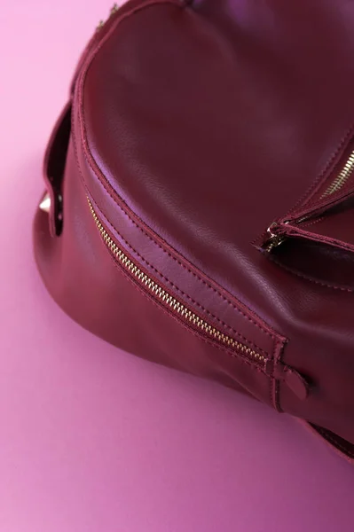 A rózsaszín háttér piros bőr hátizsák — Stock Fotó