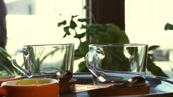 Two Glass Mugs And Teaspoons Stand On Tray — Stock Video