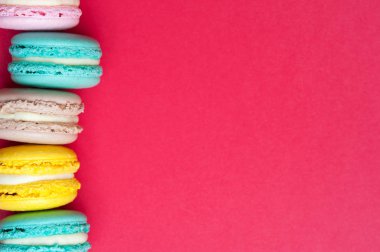 Kırmızı bir arka plan üzerinde renkli pastel macaroons