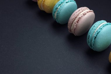 Koyu arka plan üzerinde düz yatıyordu pastel macaroons