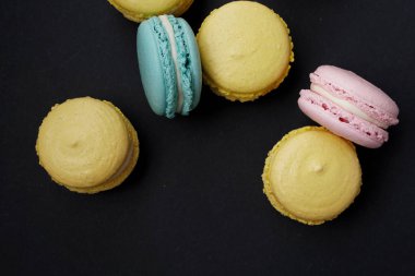 Koyu arka plan üzerinde düz yatıyordu pastel macaroons
