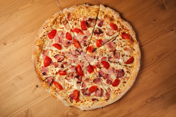 Fresh Italian pizza on wooden desk — Stock Photo, Image
