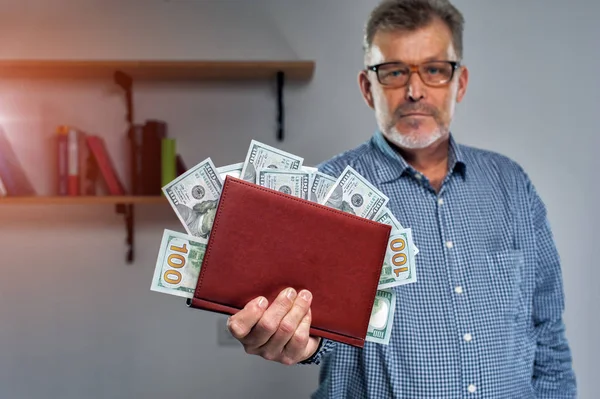 Middle aged successful businessman counts money