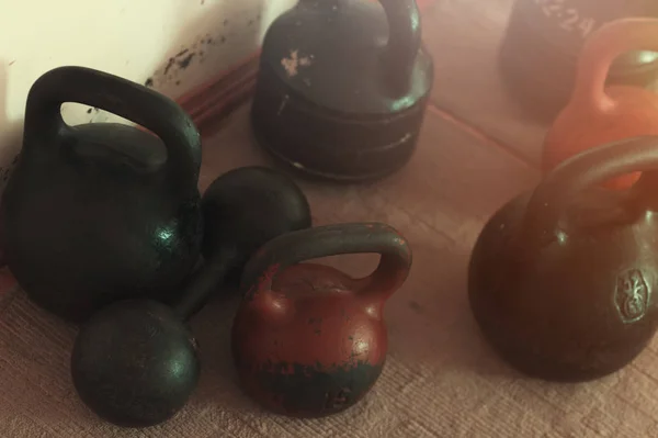 Diversi kettlebells e un manubrio sul pavimento — Foto Stock