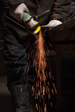 Demirci Metal ürünleri taşlama makinesi kullanarak parlatır