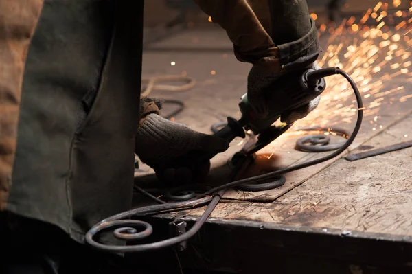 Close-up Mãos de um ferreiro elementos de solda para seu produto forjado — Fotografia de Stock