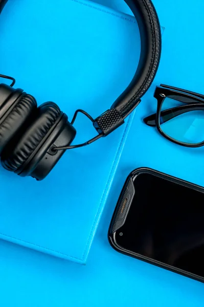 Auriculares con estilo negro sobre fondo azul . — Foto de Stock