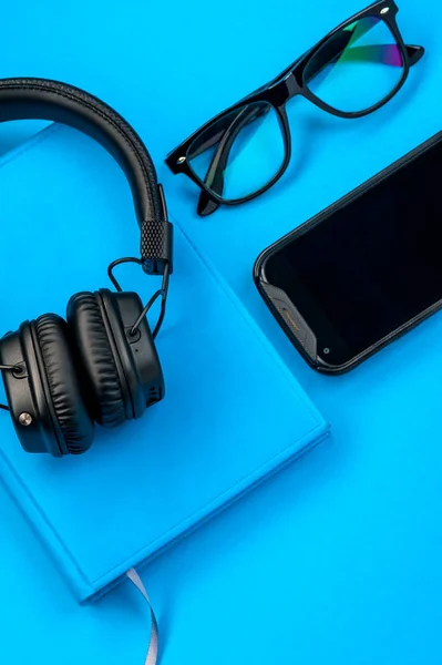 Black stylish headphones on blue background. — Stock Photo, Image