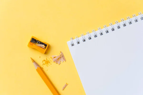 Caderno vazio e lápis sobre fundo amarelo brilhante — Fotografia de Stock