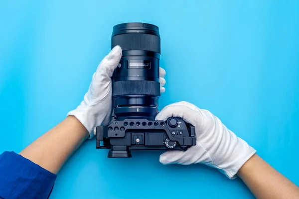 Top view female hand wearing white gloves holding professional camera — Stock Photo, Image