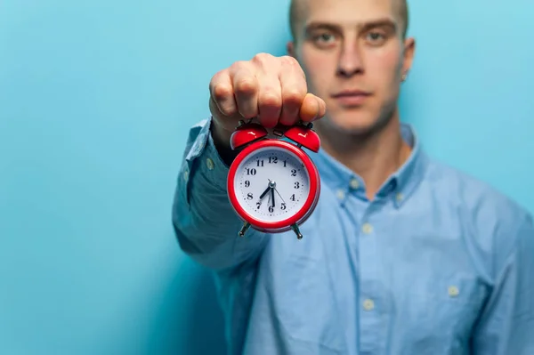 Retrato de um jovem bonitão de camisa azul posando com relógio vermelho — Fotografia de Stock