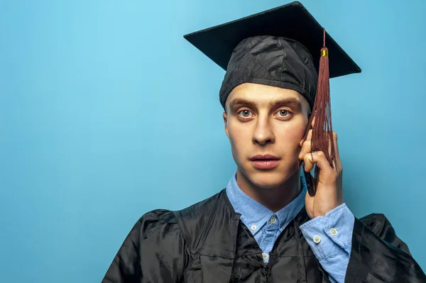 Portret studenta absolwent na niebieskim tle — Zdjęcie stockowe