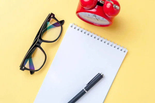 Otebook vazio, óculos em fundo amarelo . — Fotografia de Stock