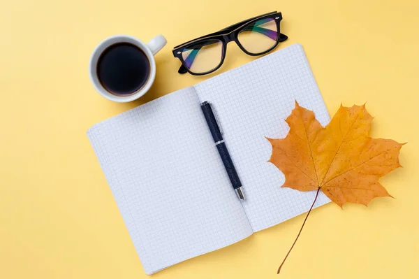 Otebook vazio, óculos em fundo amarelo . — Fotografia de Stock