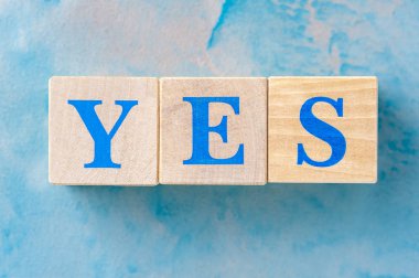 Mavi masada Evet kelimesi olan ahşap küpler.