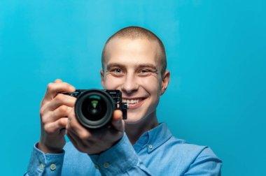 Kamera tutan pozitif genç erkek fotoğrafçı portresi