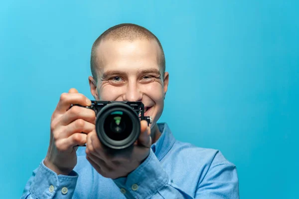 Portrait of positive young male photographer holding camera — Stock Photo, Image