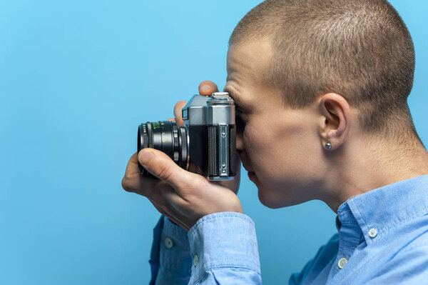 Side view of a young male photographer using vintage camera