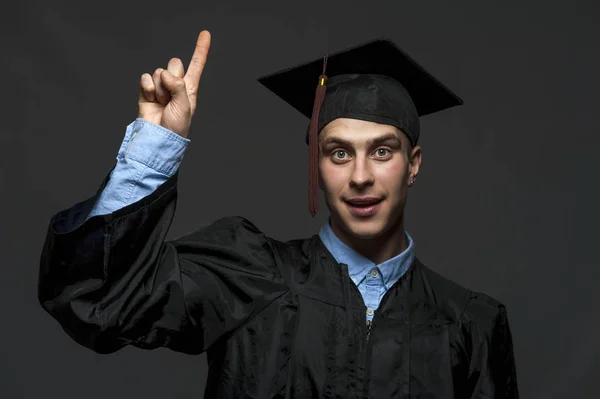 Portret absolwent dorosłego studenta w czarnej sukni ukończenia z kapeluszem — Zdjęcie stockowe