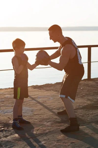Strong Young Tall Male Boxer Teaches His Little Son How To Properly Box