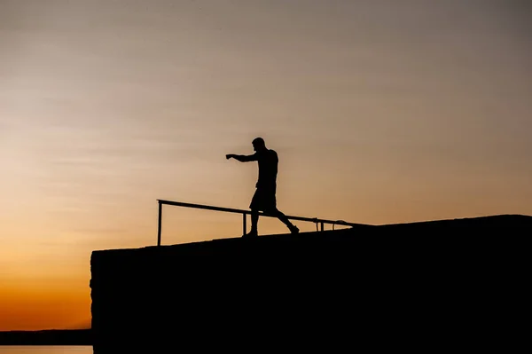 Silhouette of Young Strong Male Boxer Working Out On The Pier — Stock Photo, Image