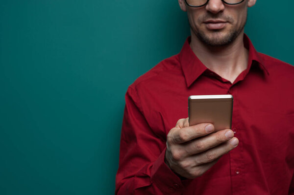 Portrait of a positive young man in glasses with phone