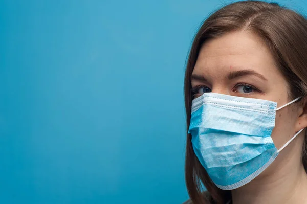 Side portrait of young woman wearing a medical mask.