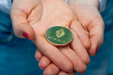 Young unidentified woman holding a etherium coin