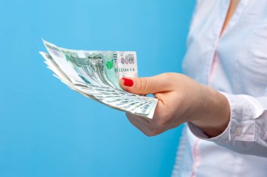 Bir paket Rus rublesi tutan kimliği belirsiz genç bir kadının elleri.