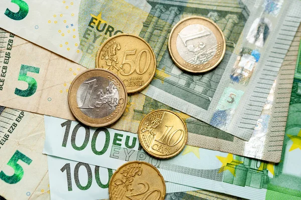 Billetes y monedas en euros de primer plano se encuentran uno al lado del otro — Foto de Stock