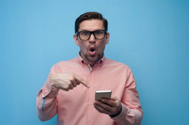 Akıllı telefonlu, gözlüklü yakışıklı bir gencin portresi.