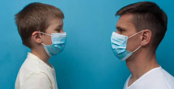 Father and son wearing protective medical mask looking to each other. — Stock Photo, Image