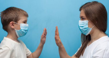 Beyaz anne ve oğul koruyucu tıbbi maske takıyor..