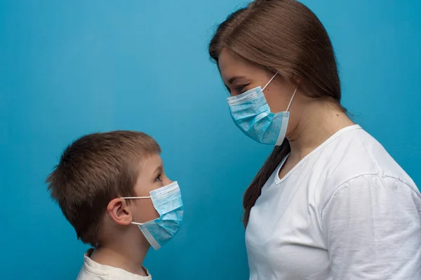 Caucasian mother and son wearing protective medical mask.