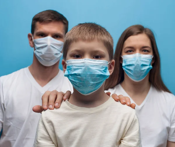 Koruyucu tıbbi maske takan anne ve baba ve çocuk.