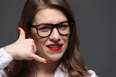 Gözlüklü ve kırmızı dudaklı genç bir kadının yakın plan portresi.