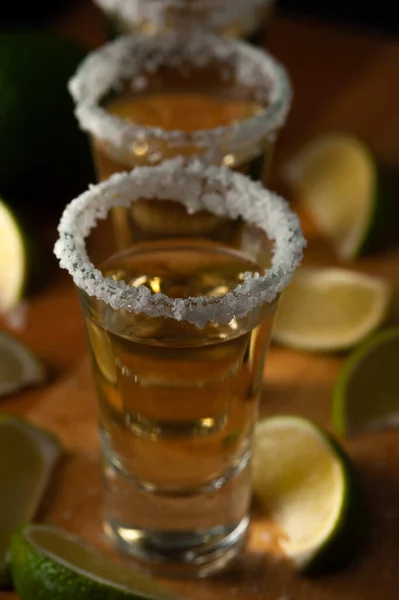 Мексиканське Tequila Gold в окулярах з нарізаними на вапно шматочками і сіллю. — стокове фото
