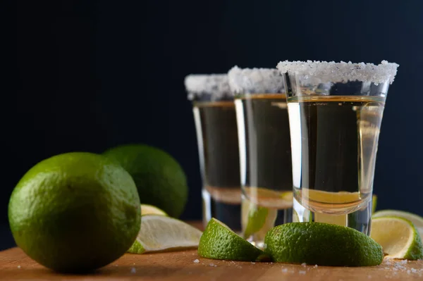 Mexická zlatá tequila s limetkovými plátky a solí. — Stock fotografie