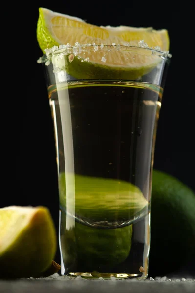 Mexicaanse tequila goud in glas met limoenschijfjes en zout. — Stockfoto