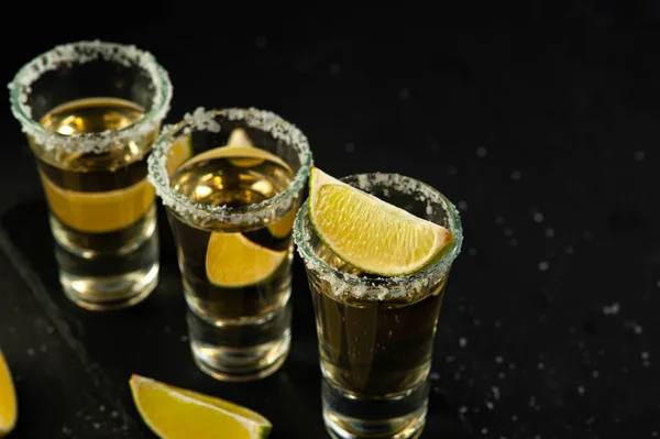 Tequila de ouro mexicano com fatias de limão e sal, vista superior — Fotografia de Stock