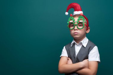 Noel aksesuarları takan üzgün bir çocuğun portresi.