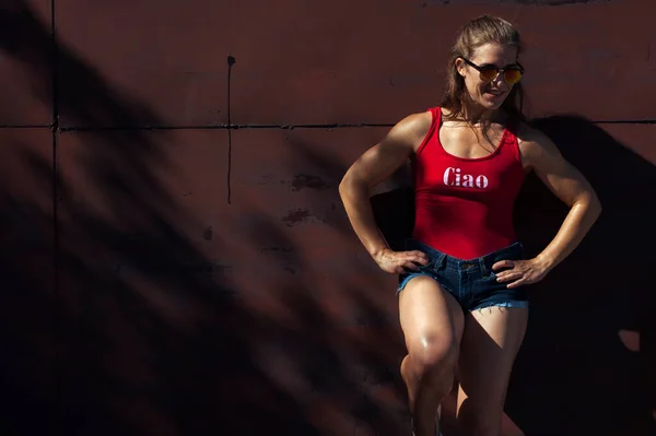 Retrato de una joven chica fitness con top rojo y jeans Imagen de stock