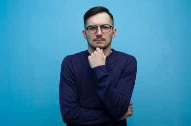 Düşünceli genç adam günlük kıyafetler giyiyor.